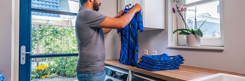 Man vouwt zijn droge schone kleding op. Man vouwt zijn droge schone kleding op.