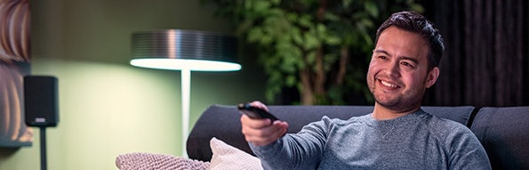 Man zit op de bank te genieten van zijn persoonlijke aanbod via Samsung Vision AI.