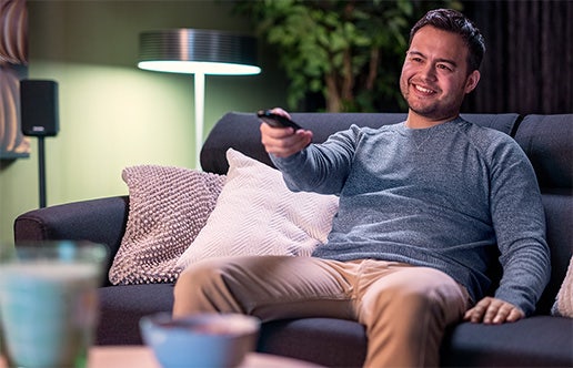 Man zit op de bank te genieten van zijn persoonlijke aanbod via Samsung Vision AI.