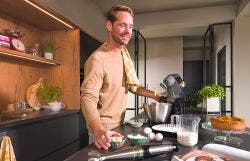 Man staat in keuken